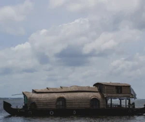 Kerala Boat House floating on scenic backwaters under cloudy sky