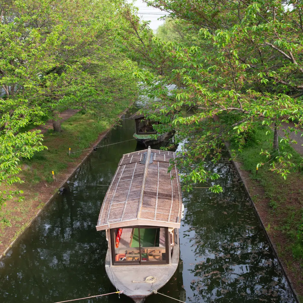 Traditional houseboat on the Alleppey houseboat route in Kerala backwaters surrounded by lush greenery.